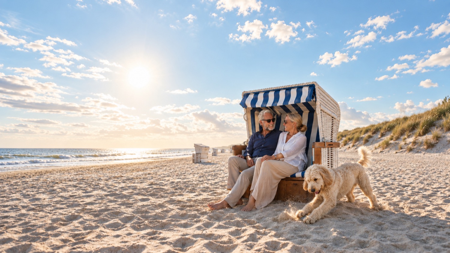 Paar mit Goldendoodle im Strandkorb am Weststrand von Sylt